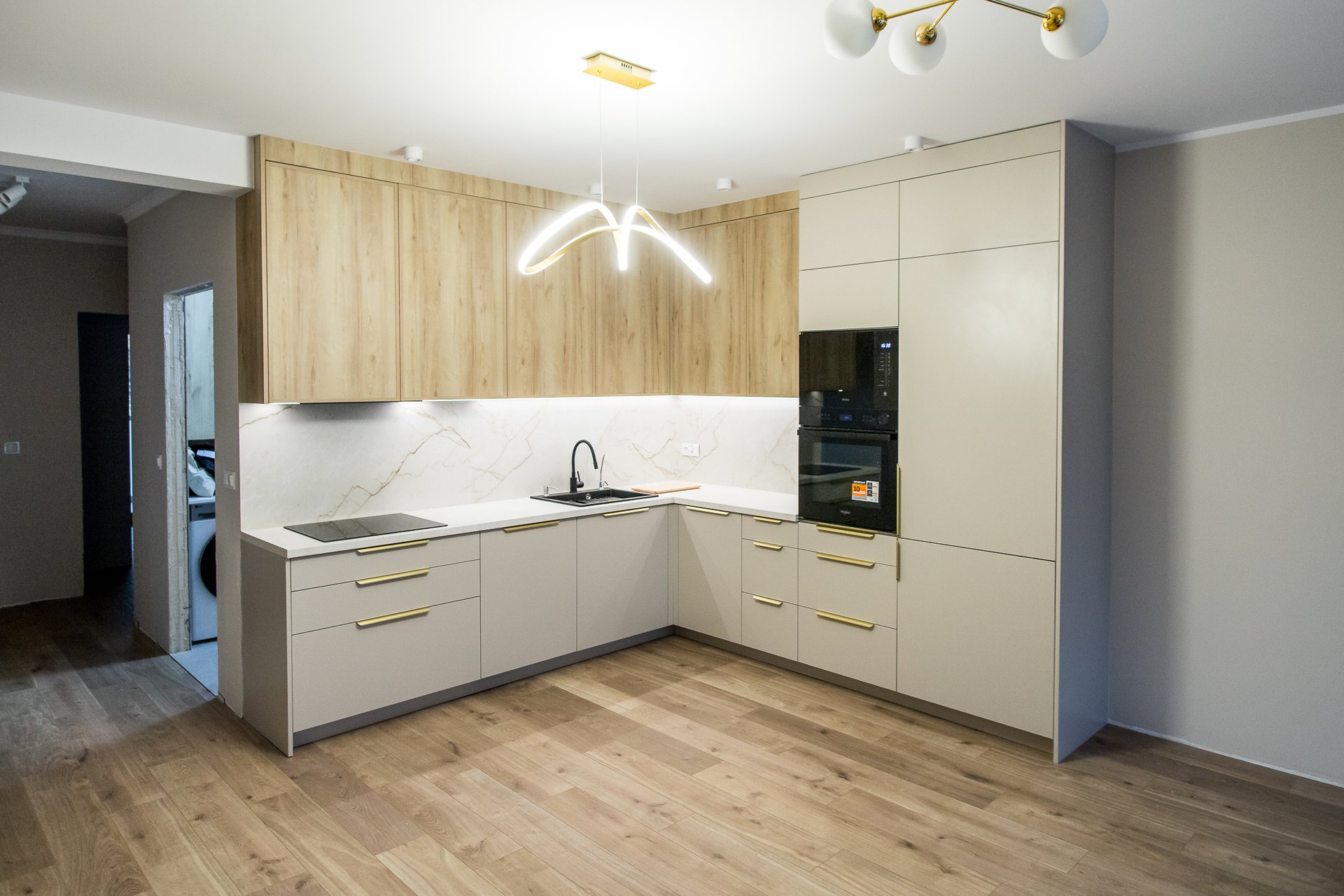 Nowoczesna kuchnia z frontami laminowanymi i złotymi uchwytami