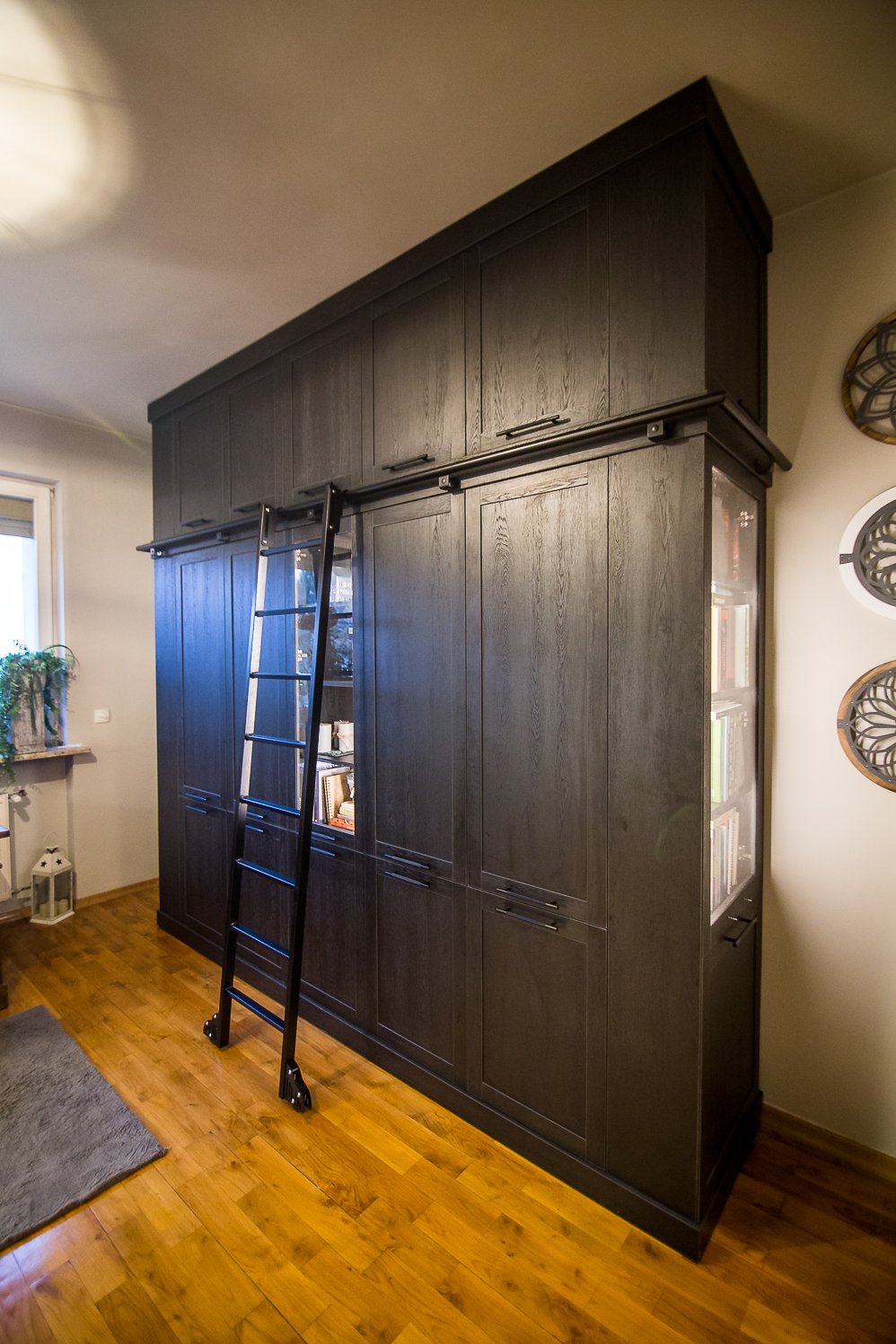 Ciemny regał z frontami ramiakowym i przeszkleniem